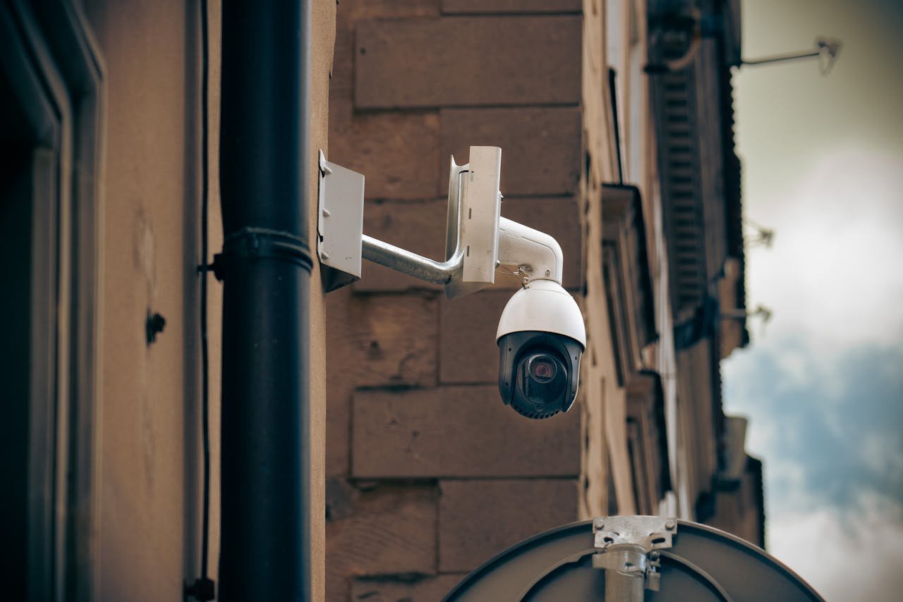 CCTV camera mounted on a building wall in an urban street setting, enhancing security.